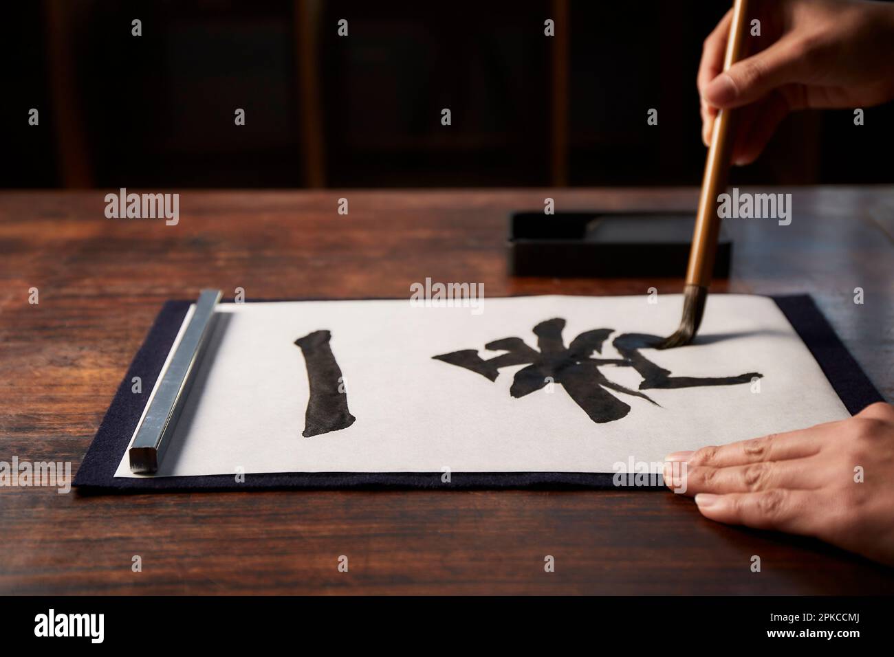 Woman's hand doing calligraphy at a desk Stock Photo