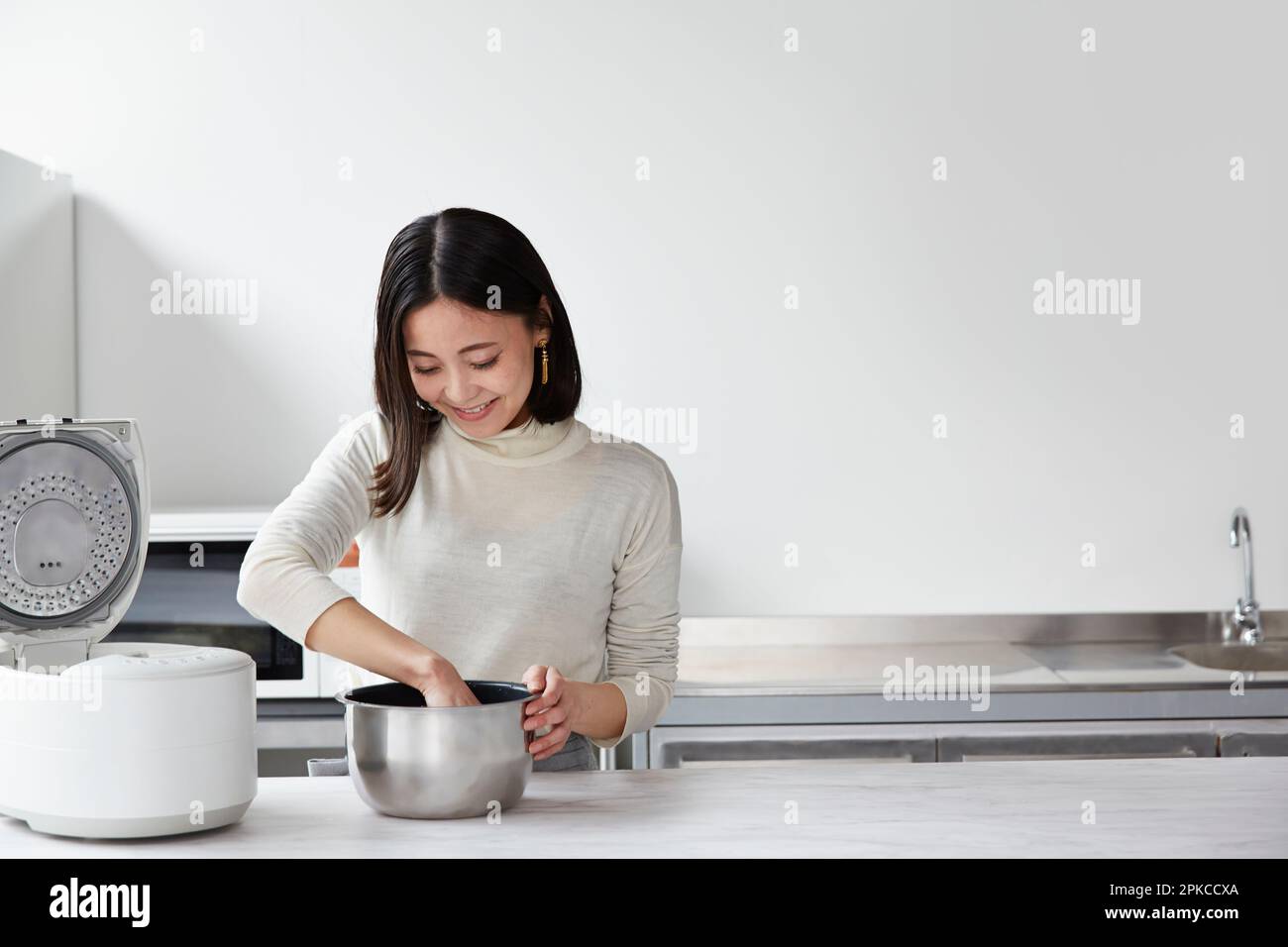 Woman grinding rice Stock Photo