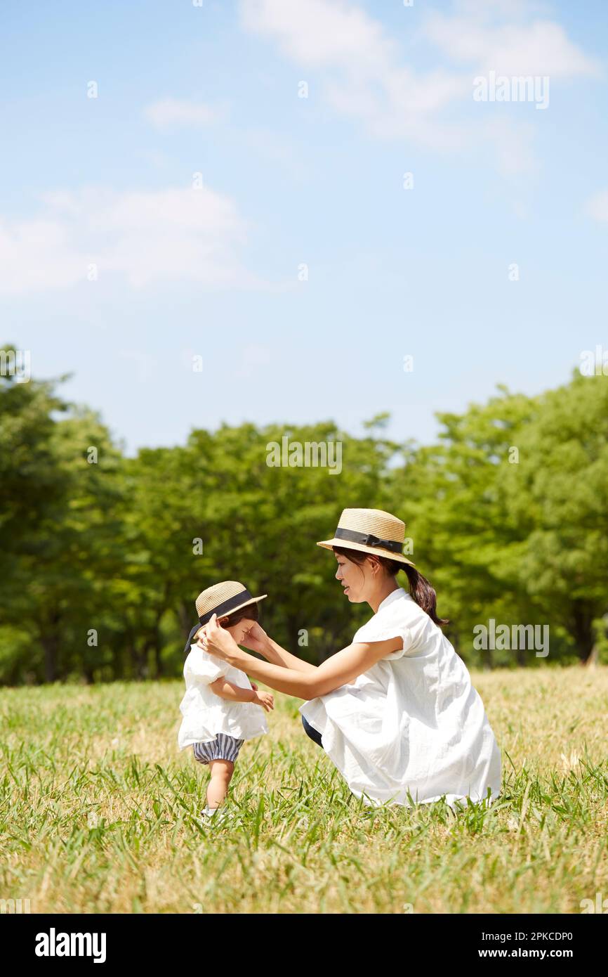 Mother and daughter wearing matching hats on the grass Stock Photo