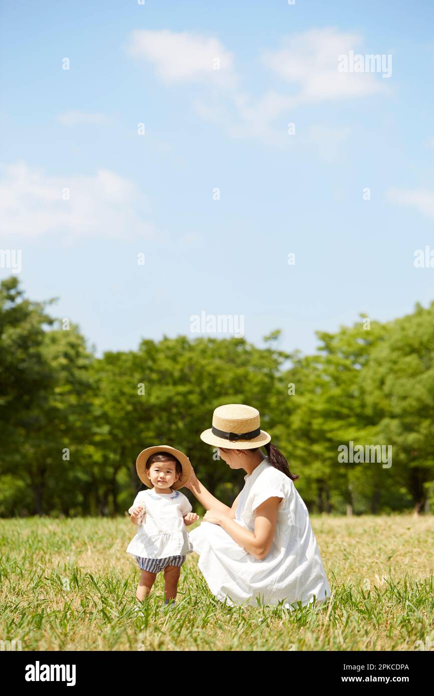 Mother and daughter wearing matching hats on the grass Stock Photo
