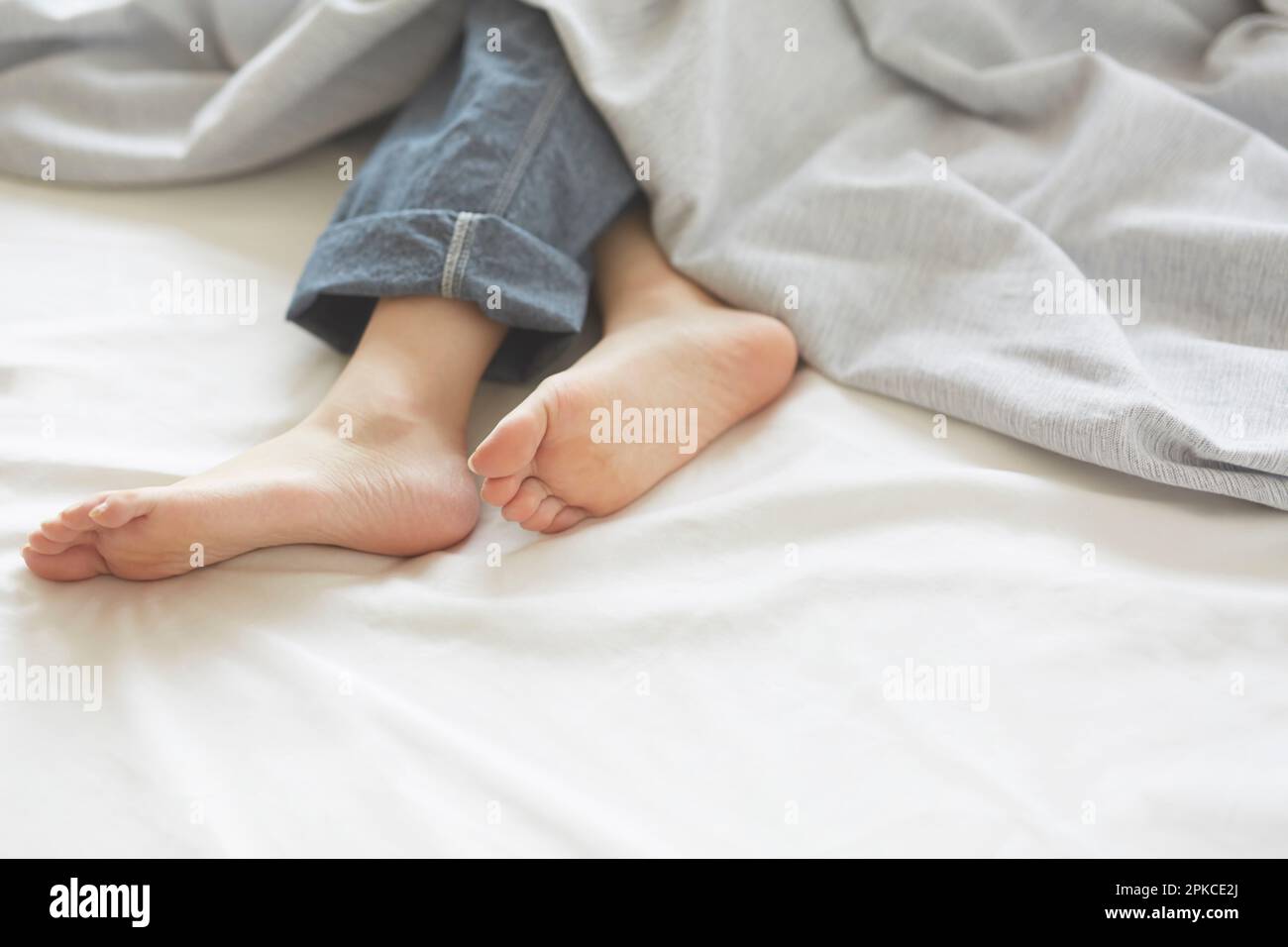 Woman's feet sleeping on white sheets Stock Photo Alamy
