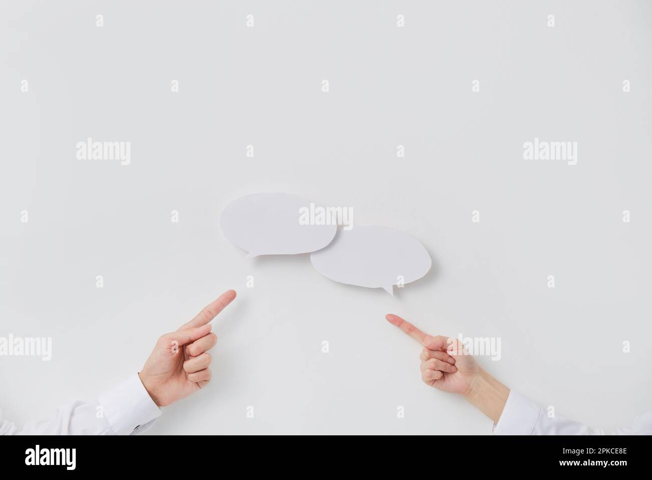 A speech balloon expressing an exchange of opinions and the hands of a man and a woman Stock Photo