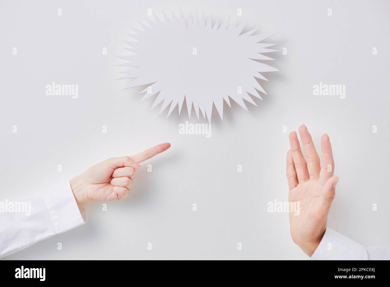 Jagged speech balloon and fighting man and woman's hands Stock Photo