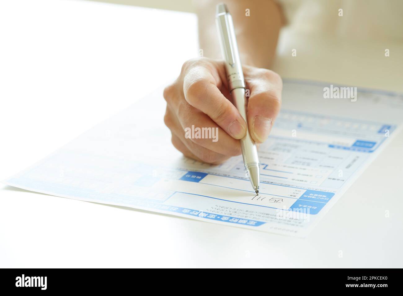 Woman's hand filling out paperwork Stock Photo