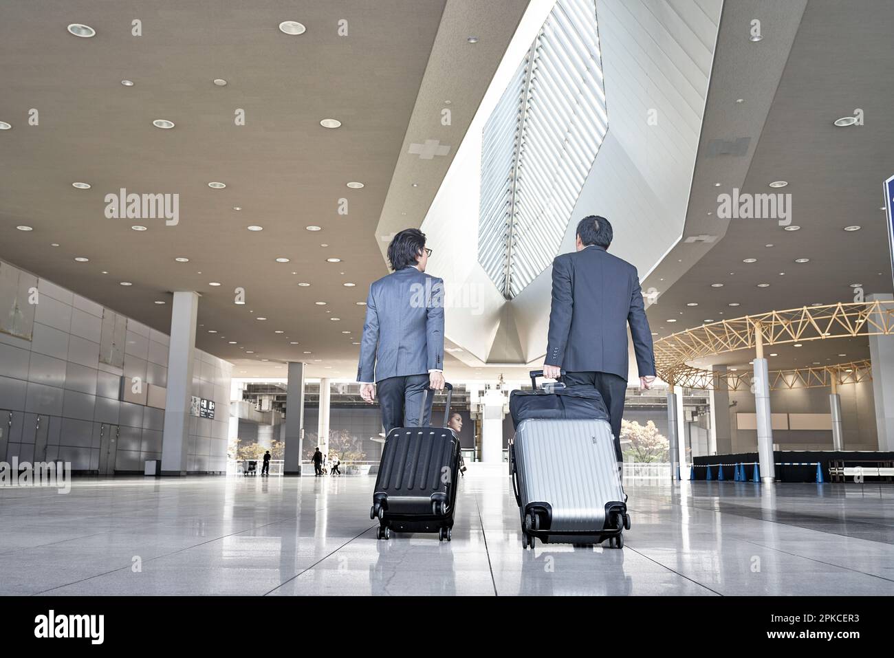 A businessman pulling a carryon case at the airport Stock Photo Alamy