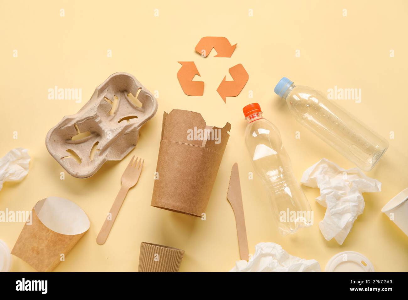 Recycling sign with garbage on yellow background Stock Photo - Alamy
