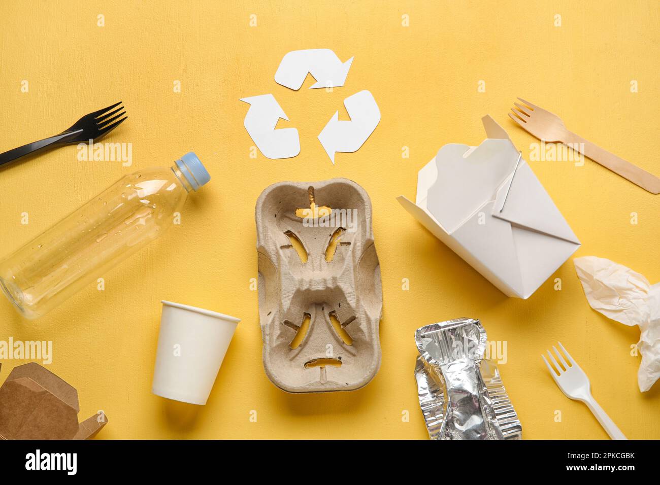 Recycling sign with garbage on yellow background Stock Photo - Alamy