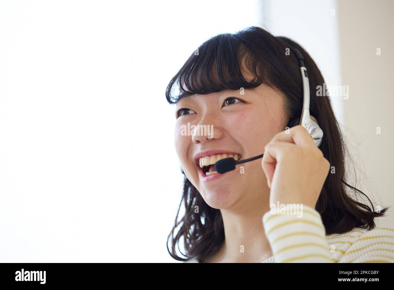 Woman wearing headphones and talking with a smile Stock Photo Alamy