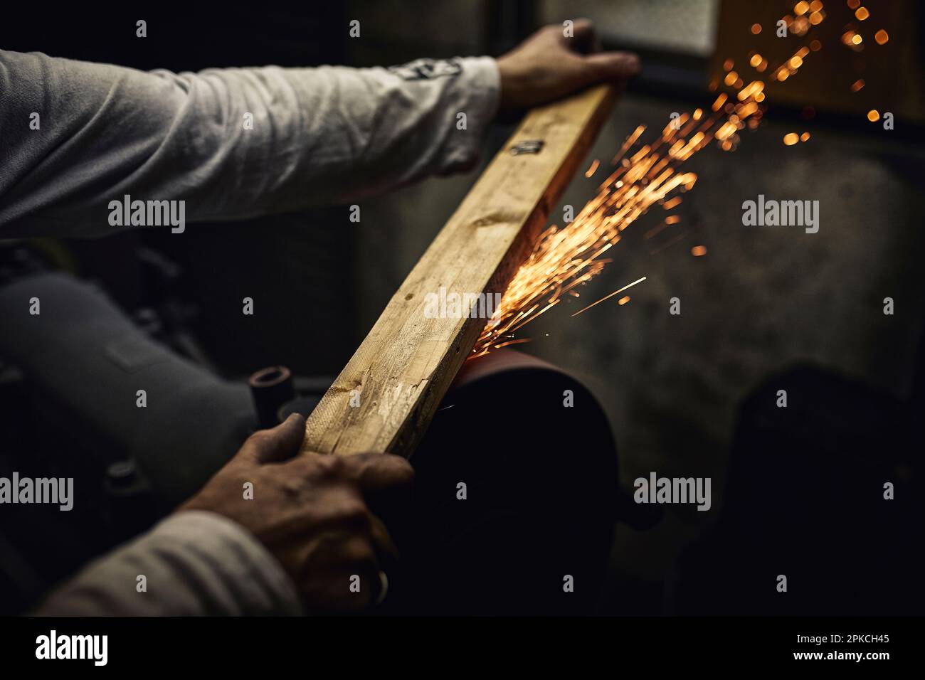 A man working at a cutlery factory with sparks flying Stock Photo