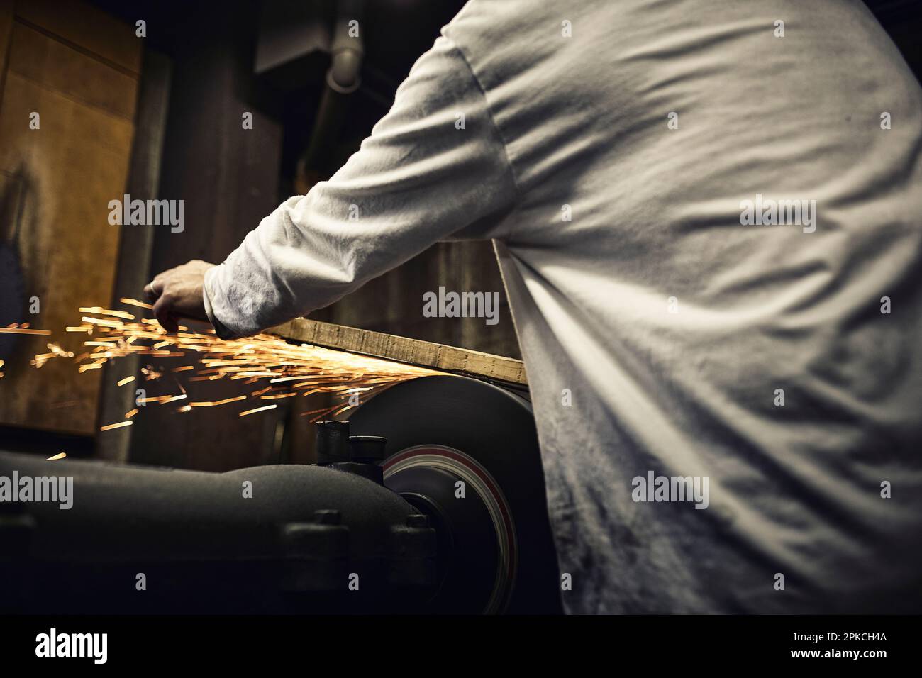 A man working with sparks in a cutlery factory Stock Photo
