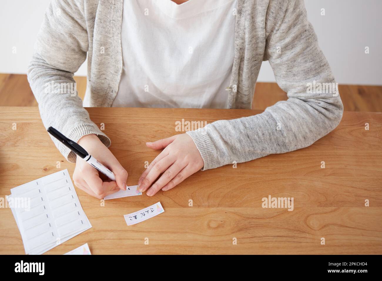 A woman writing her name on a name tag Stock Photo - Alamy