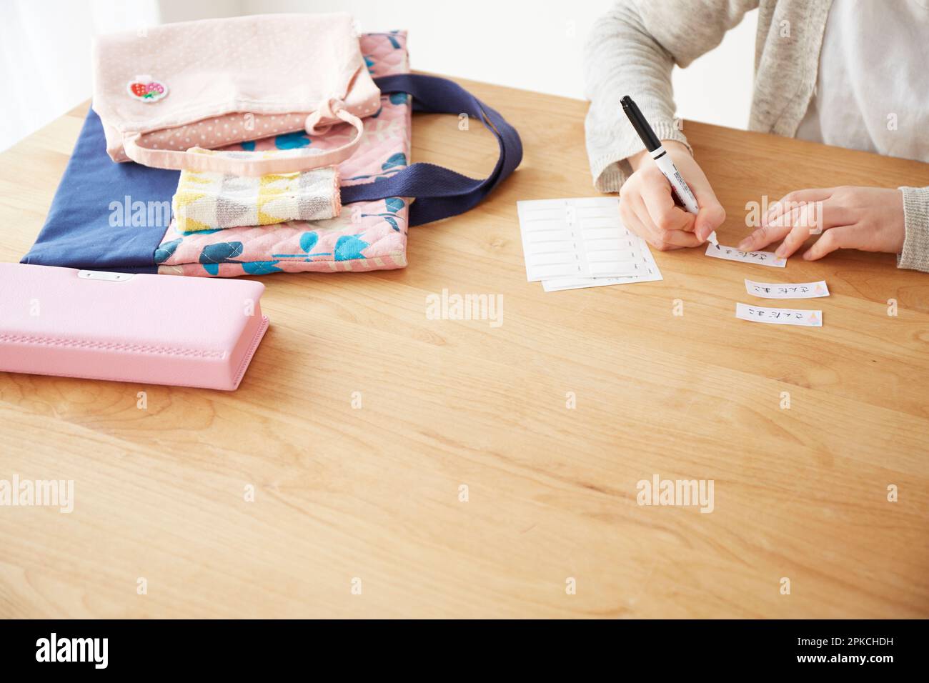 Woman writing her name on a name tag Stock Photo