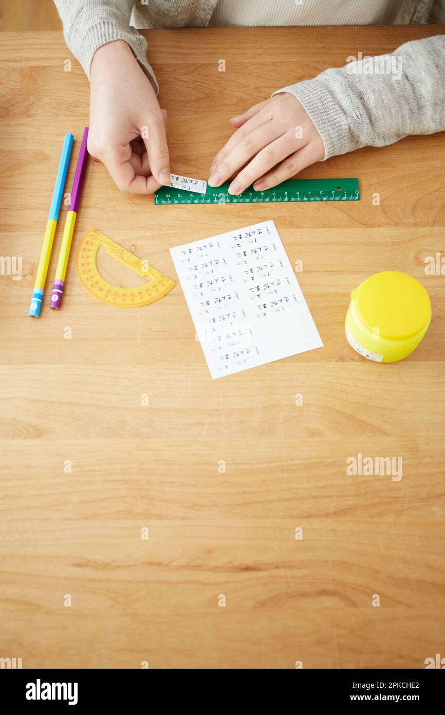 Woman attaching name stickers to school supplies Stock Photo
