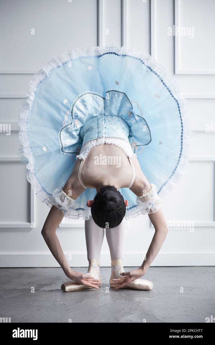Ballerina bending forward in a dress Stock Photo