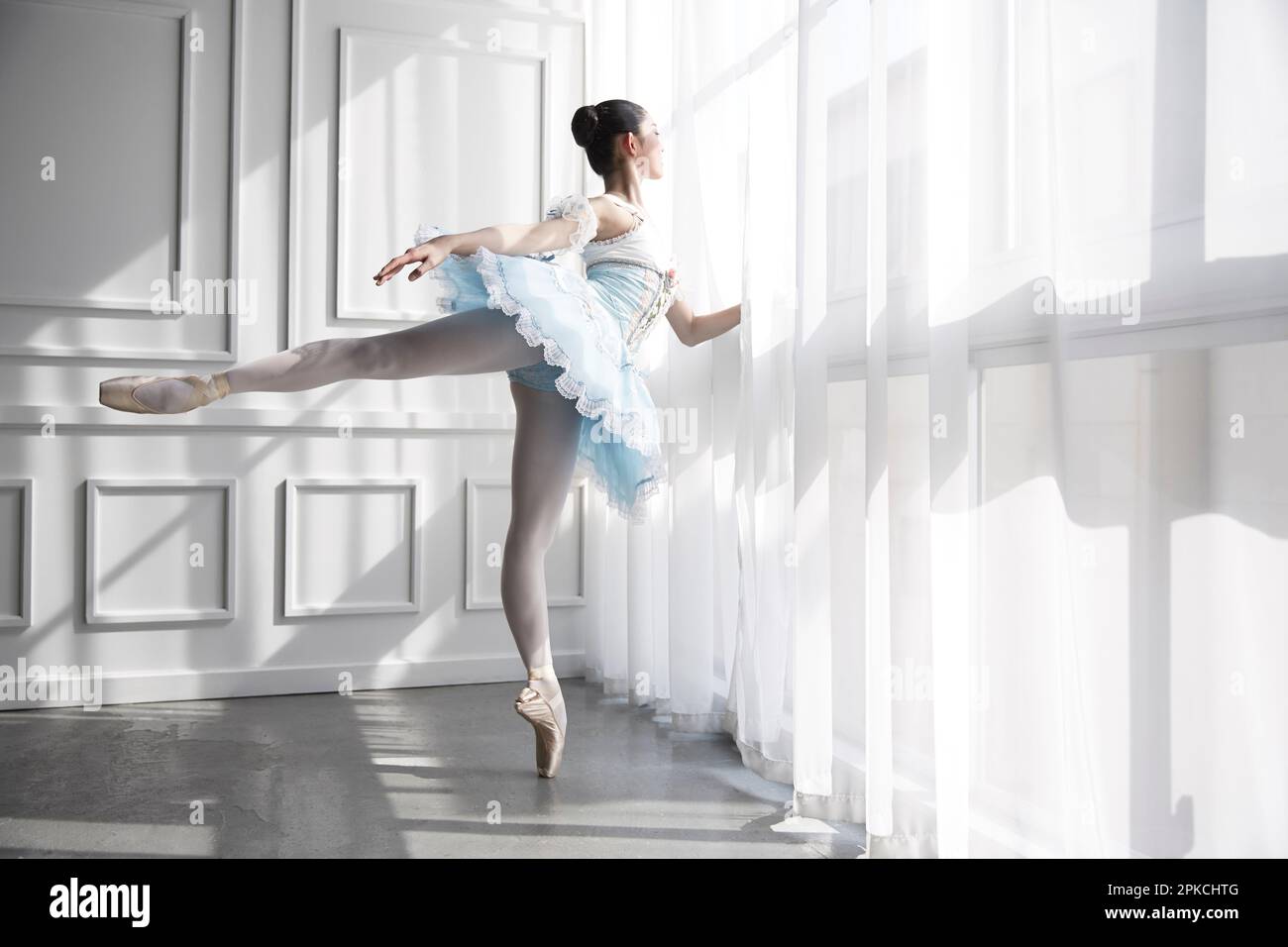 Ballerina standing by the window Stock Photo