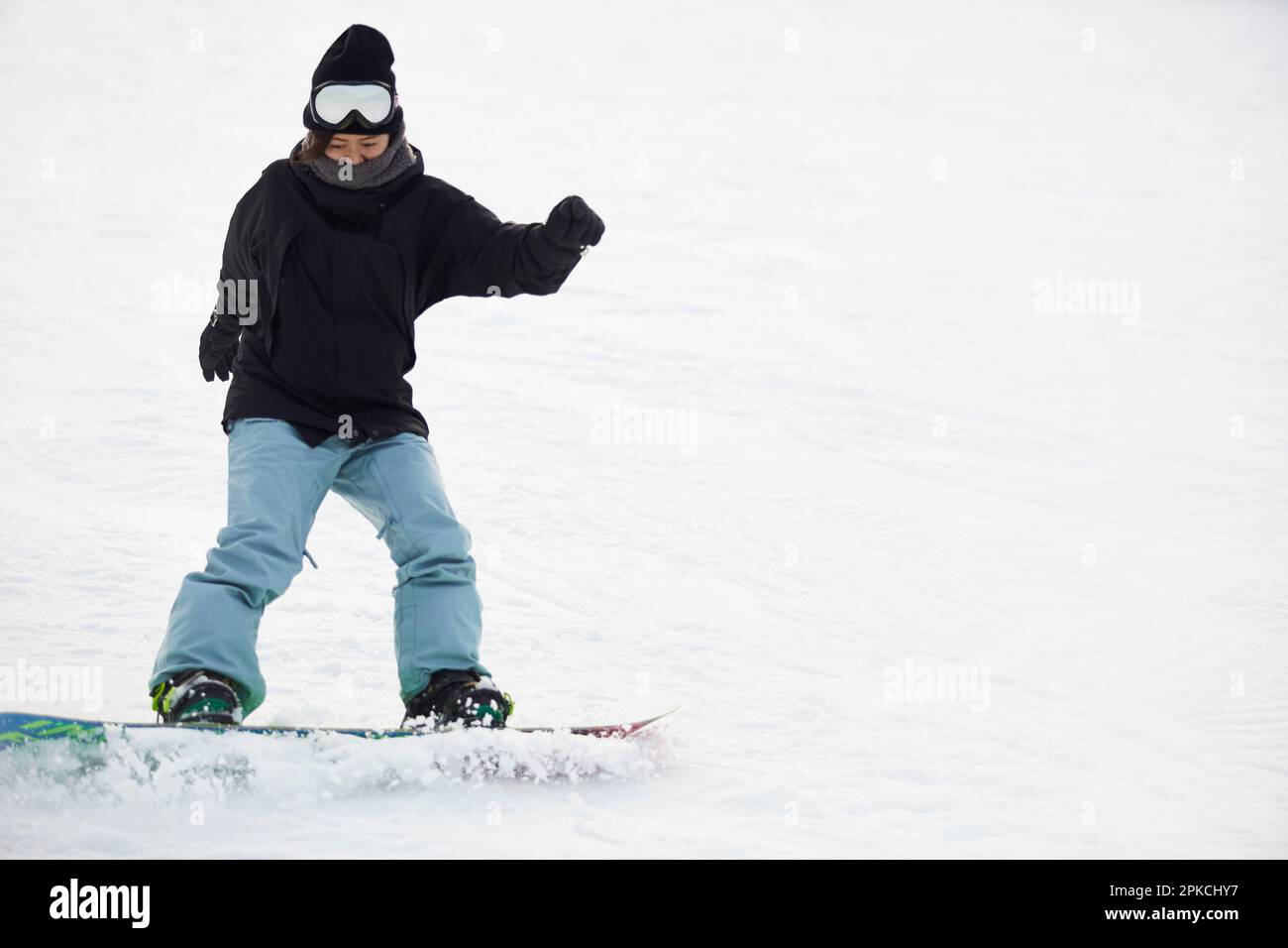Woman snowboarding Stock Photo