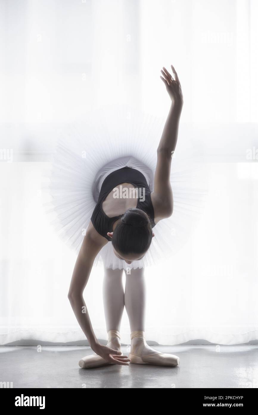 Ballerina doing a forward bend Stock Photo