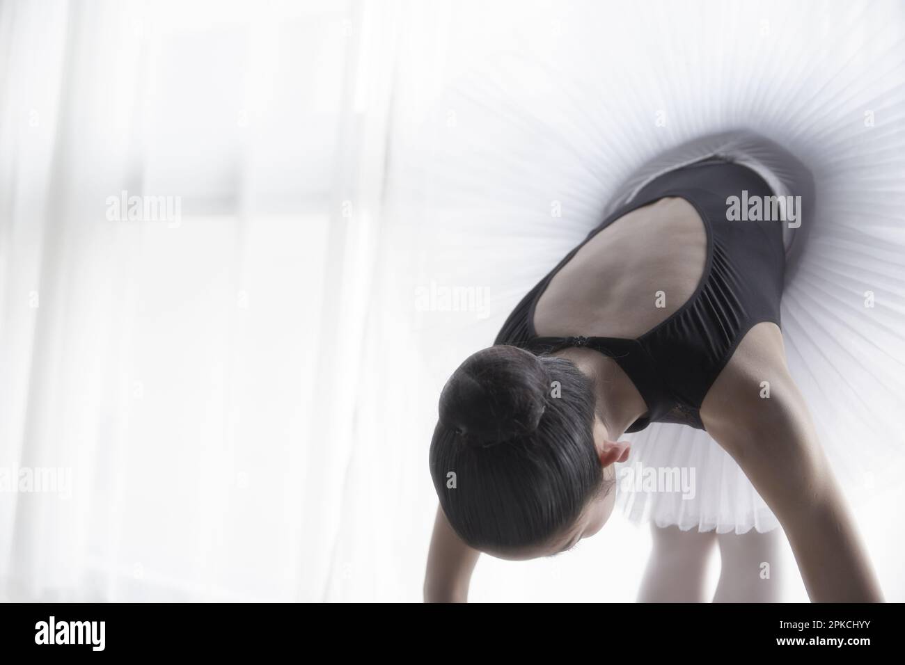 Ballerina doing a forward bend Stock Photo
