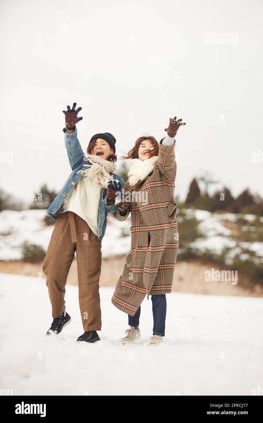 Two women playing in a snowy square Stock Photo