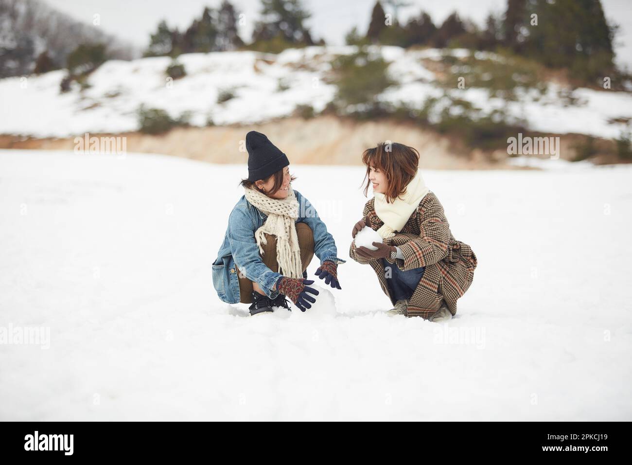 Two women playing in a snowy square Stock Photo