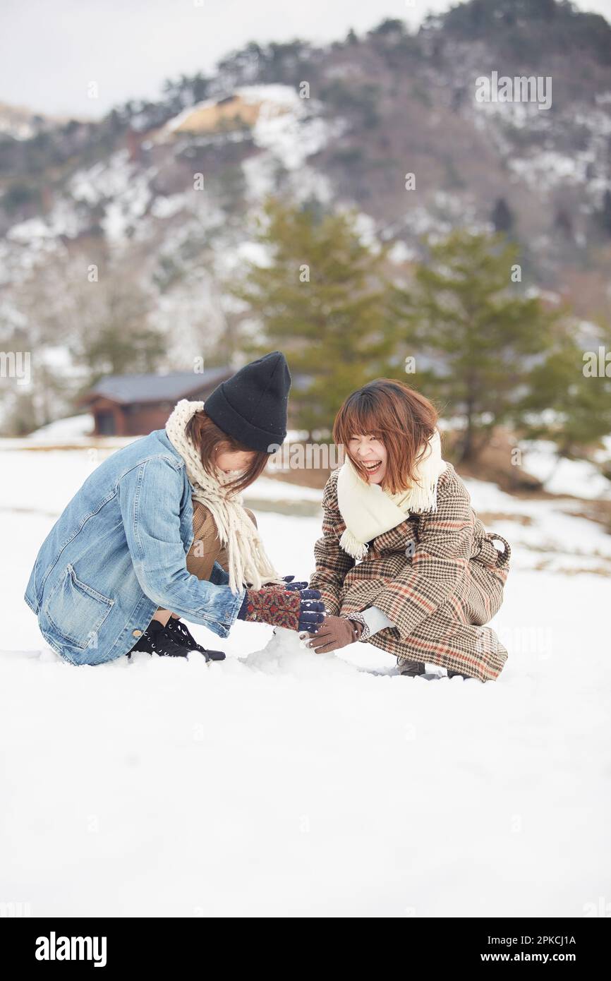 Two women playing in a snowy square Stock Photo
