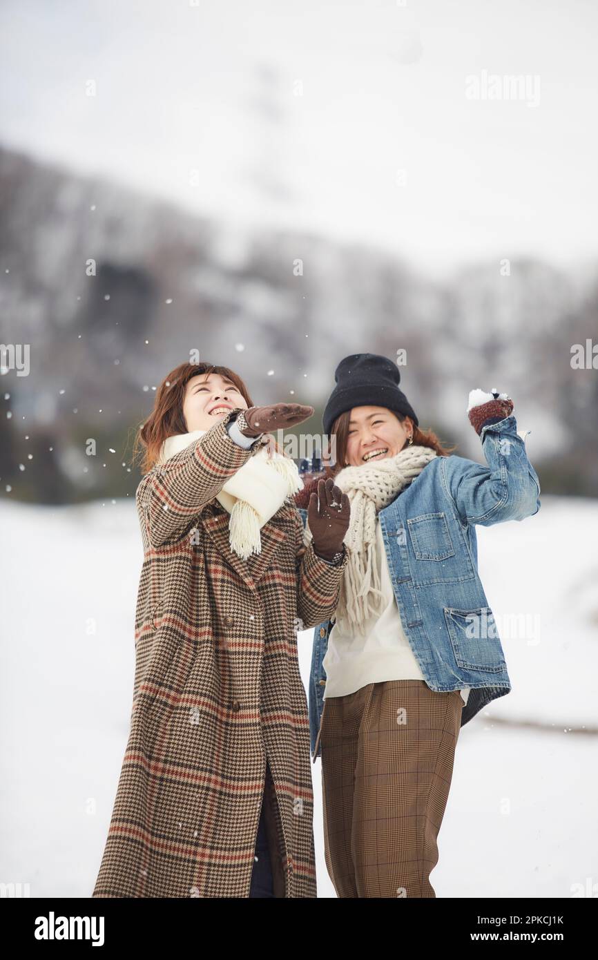 Two women playing in a snowy square Stock Photo