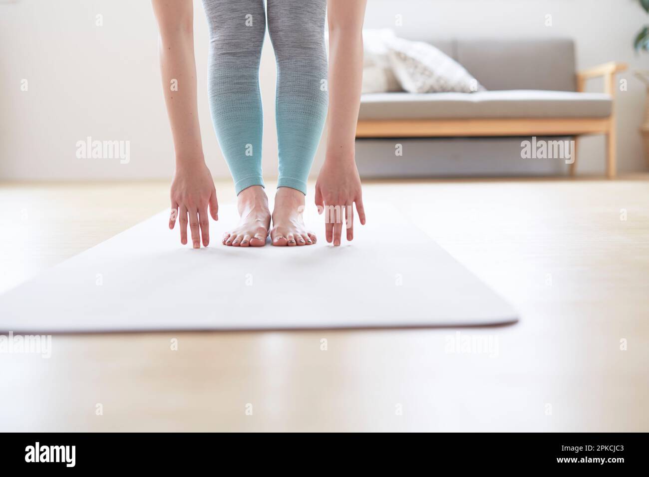 Woman's hands on yoga mat bending forward on the floor Stock Photo