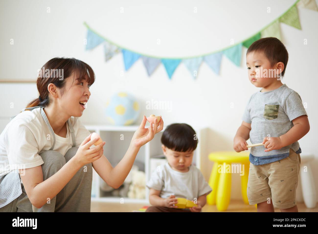 nursery-school-teacher-with-children-playing-in-the-nursery-stock-photo