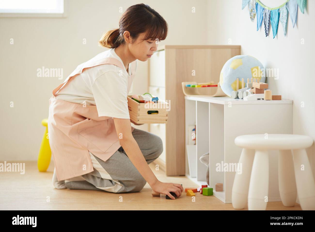 Daycare worker cleaning up afterwards Stock Photo