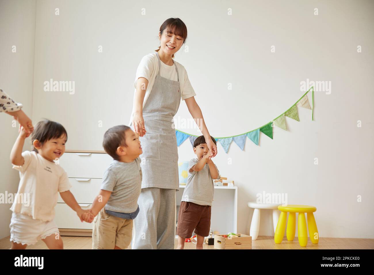 Child care worker taking care of children at a daycare center Stock Photo