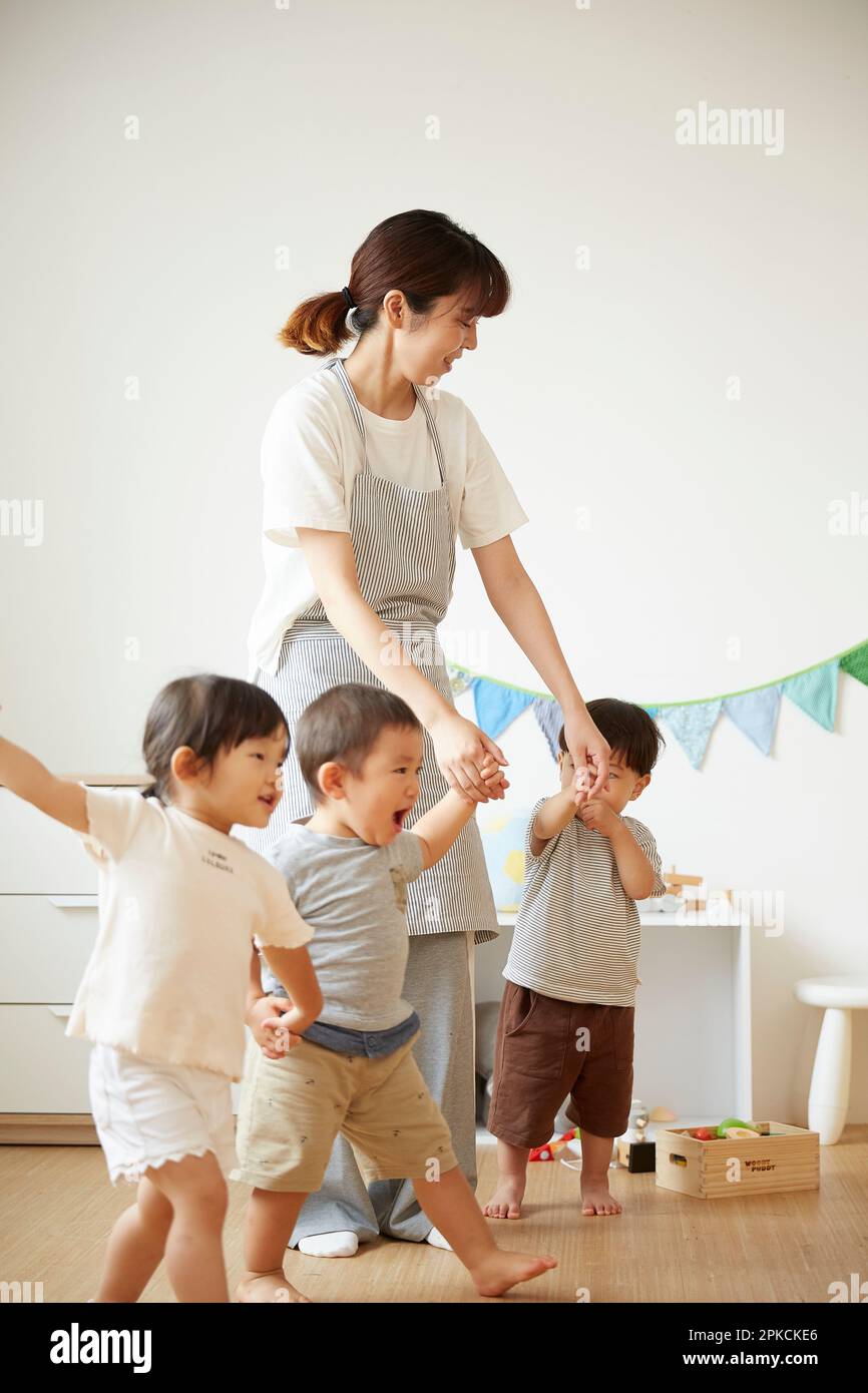 Child care worker taking care of children at a daycare center Stock Photo