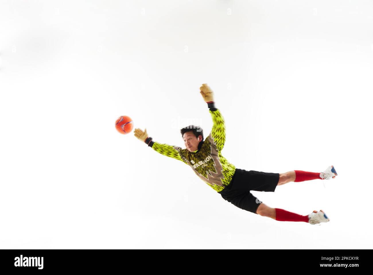 Goalkeeper trying to jump out and grab the ball Stock Photo - Alamy