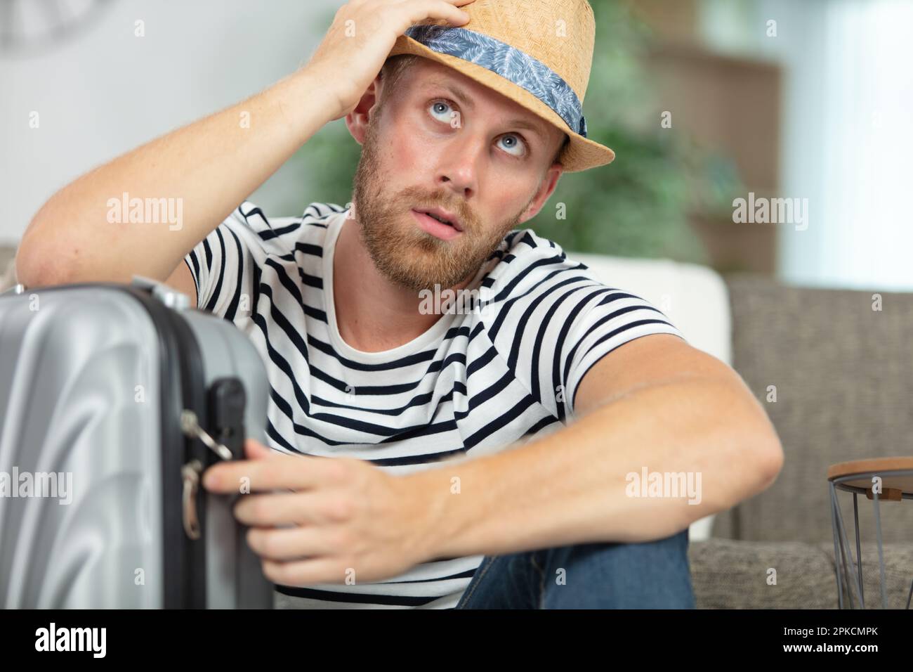 man trying to remember the code for his suitcase lock Stock Photo