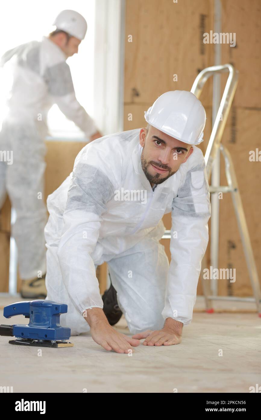 builder using sander on floor Stock Photo