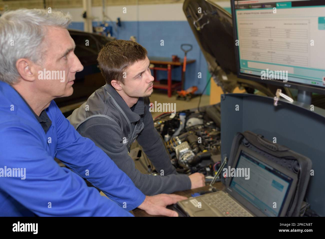 student with instructor repairing a car during apprenticeship Stock ...
