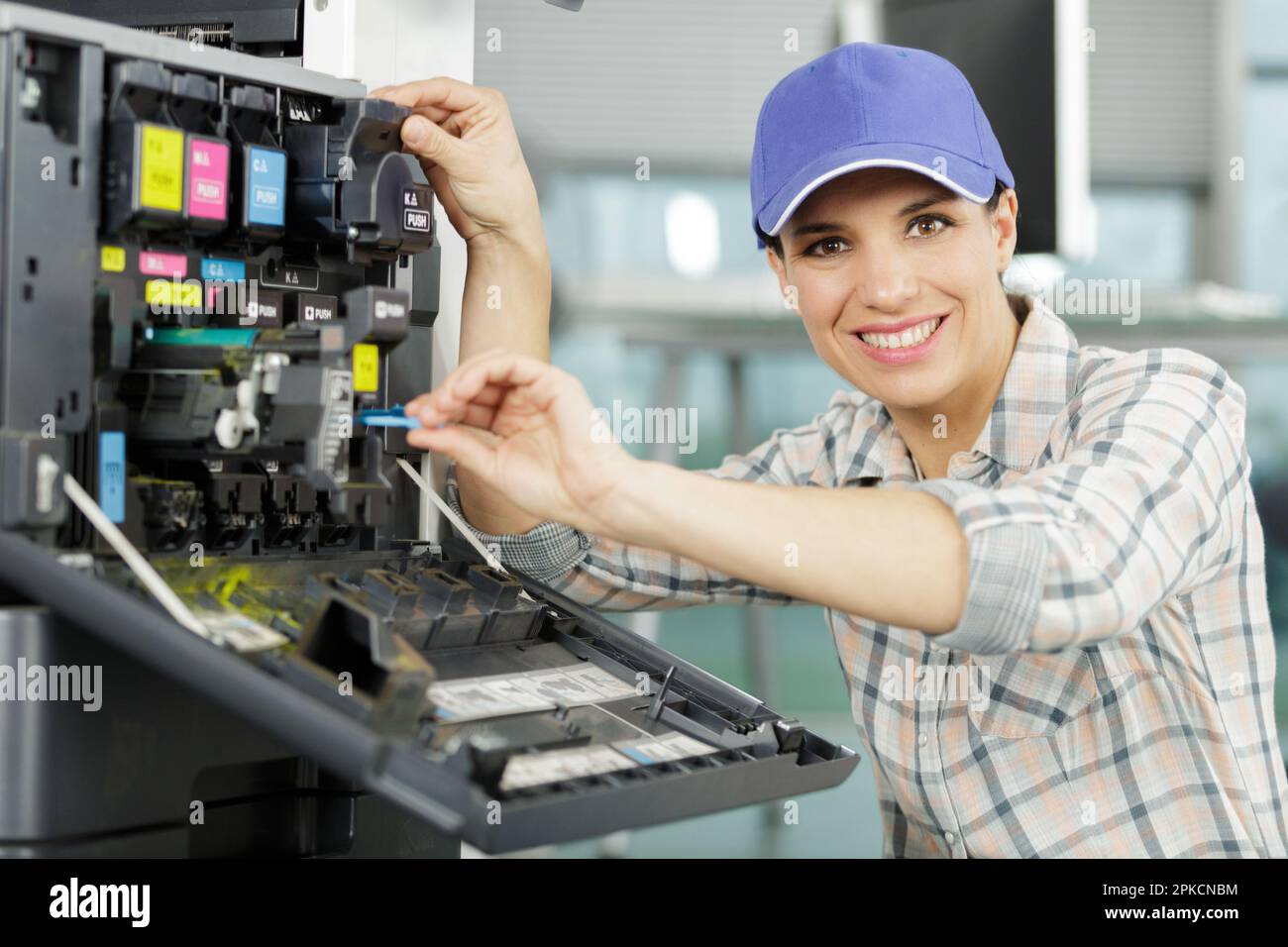 happy woman fixing a printer Stock Photo