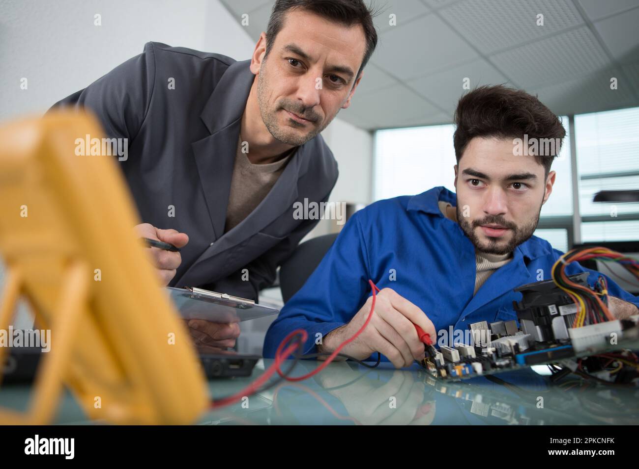 happy electronic engineers examining digital multimeter Stock Photo Alamy