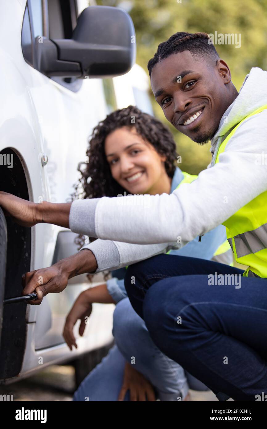 couple after a car breakdown changing the wheel Stock Photo