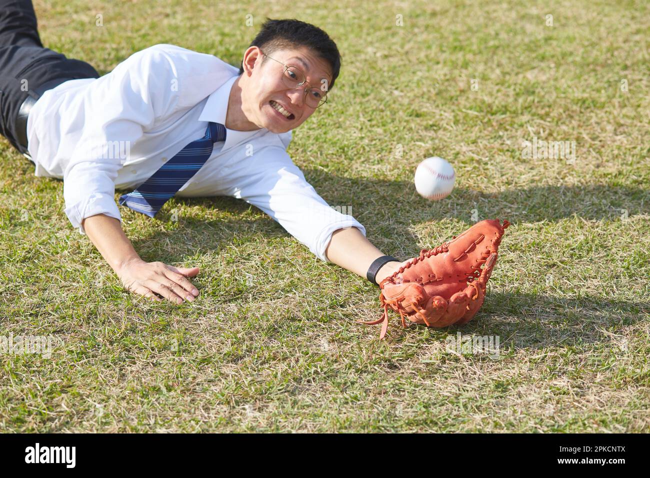 Man in suit diving to catch baseball Stock Photo Alamy