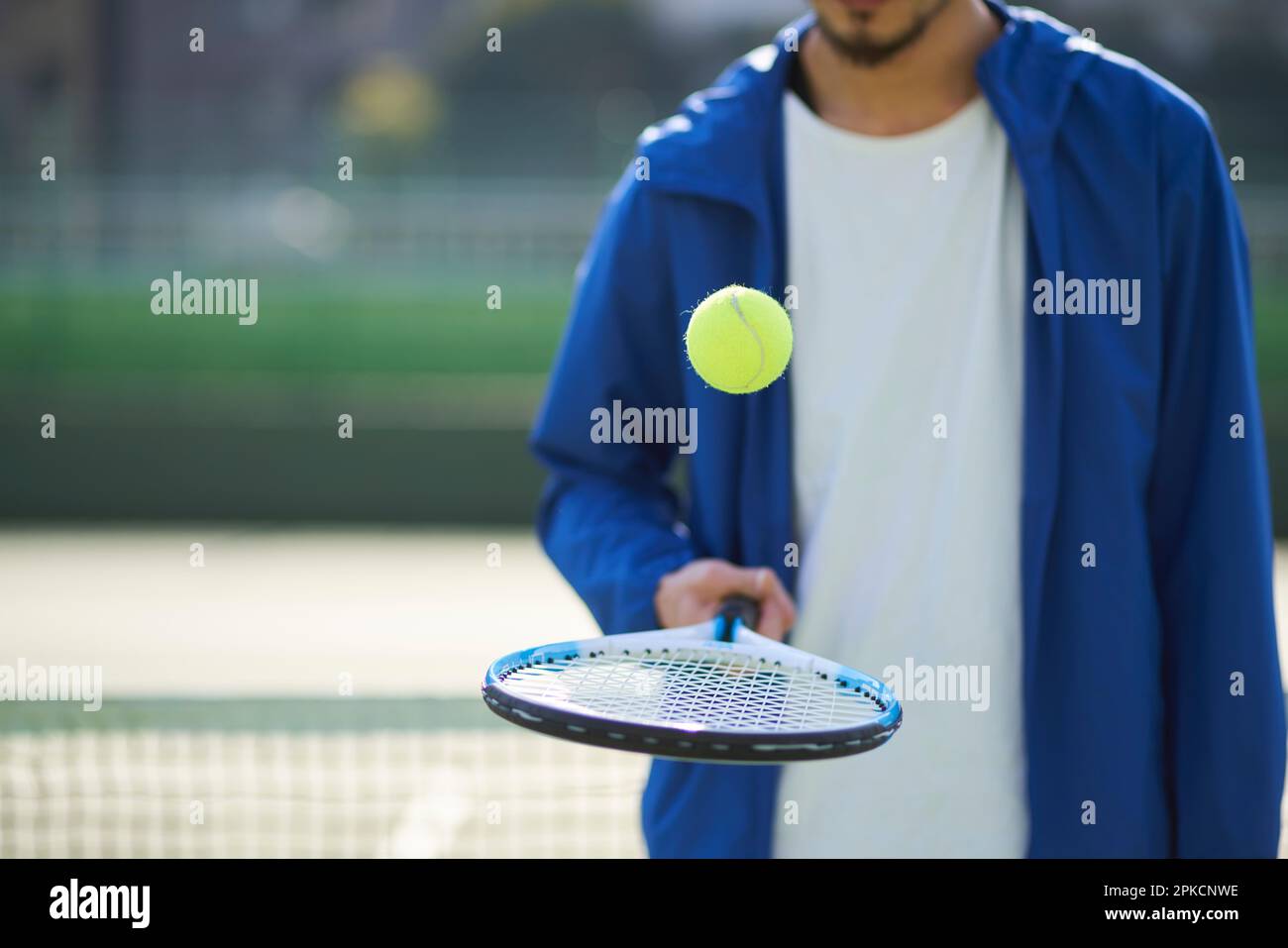 Man bouncing ball on racket Stock Photo