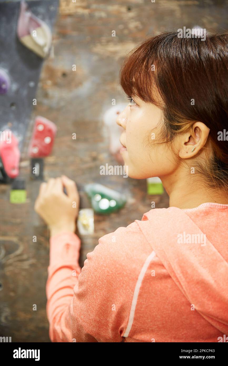 Woman grabbing a hold in bouldering Stock Photo