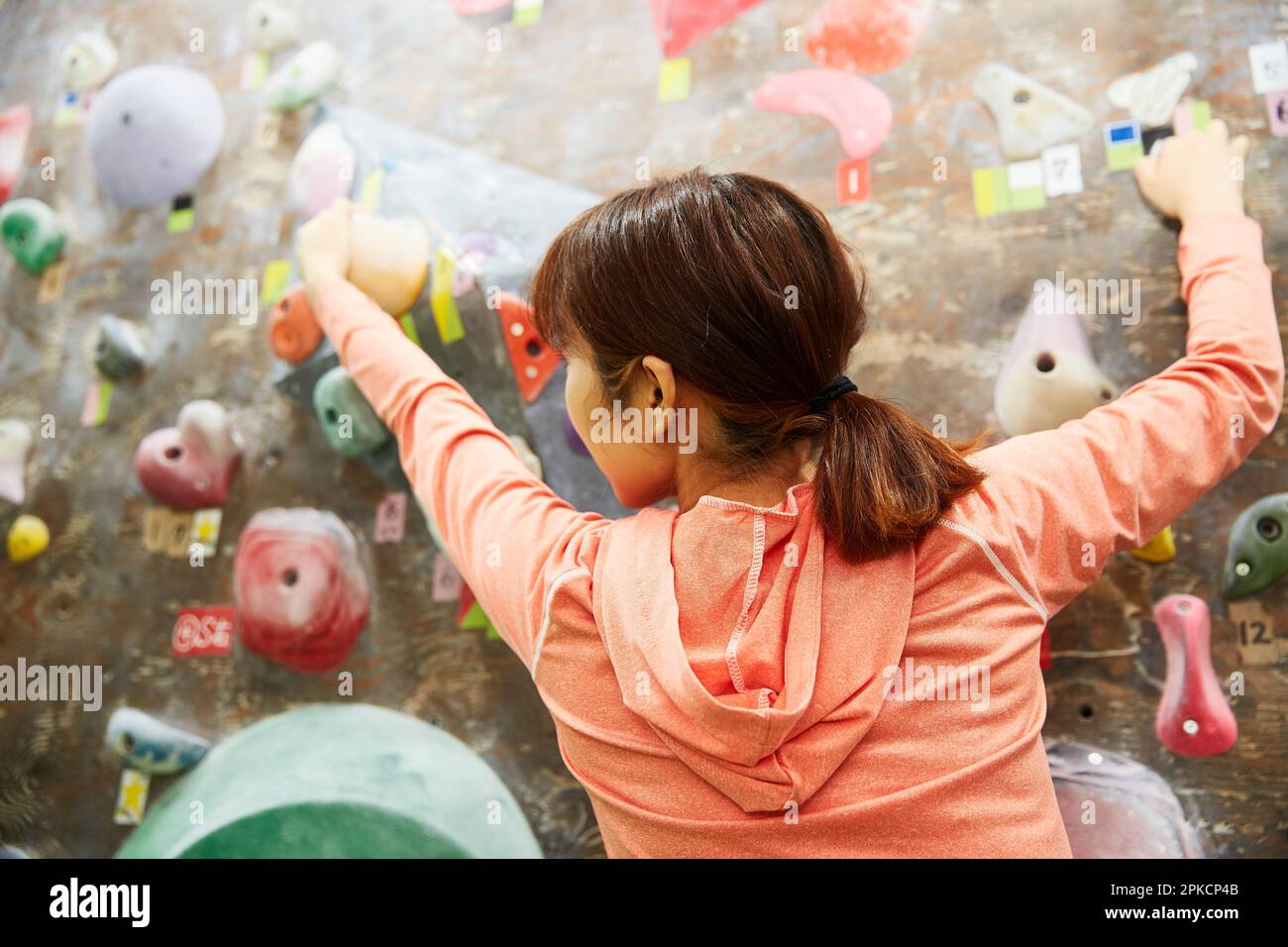 Woman reaching for next hold in bouldering Stock Photo