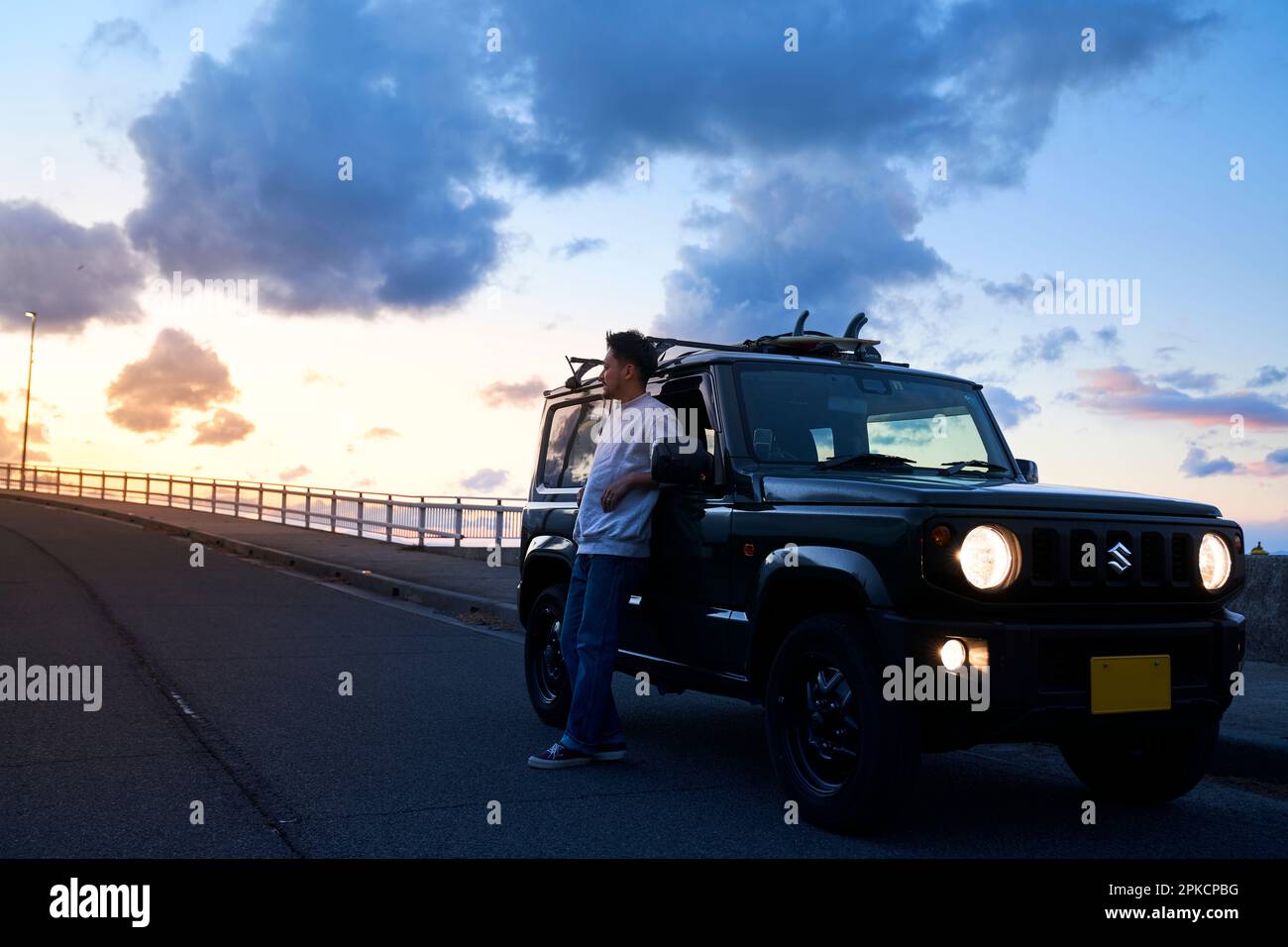 Man pulling over to watch the sunset Stock Photo
