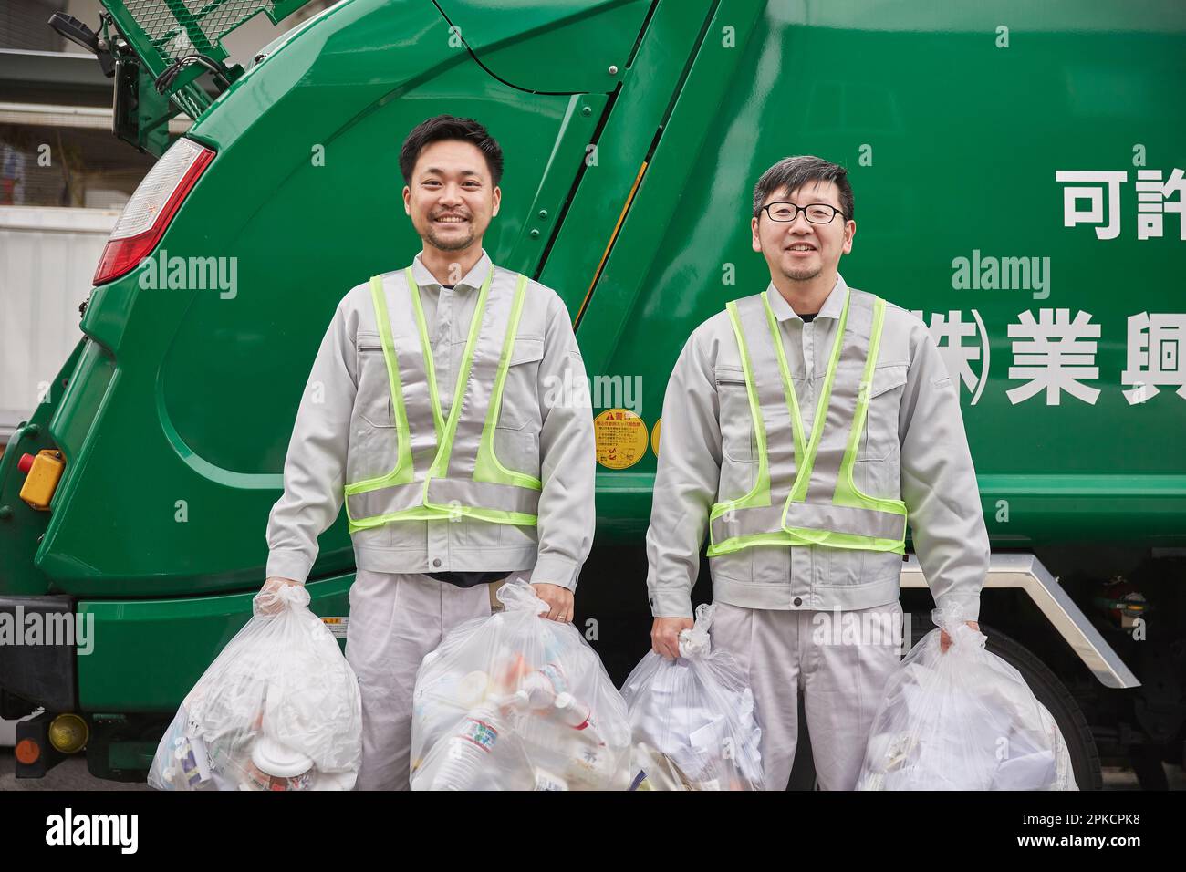 Male worker with a packer truck and garbage Stock Photo Alamy