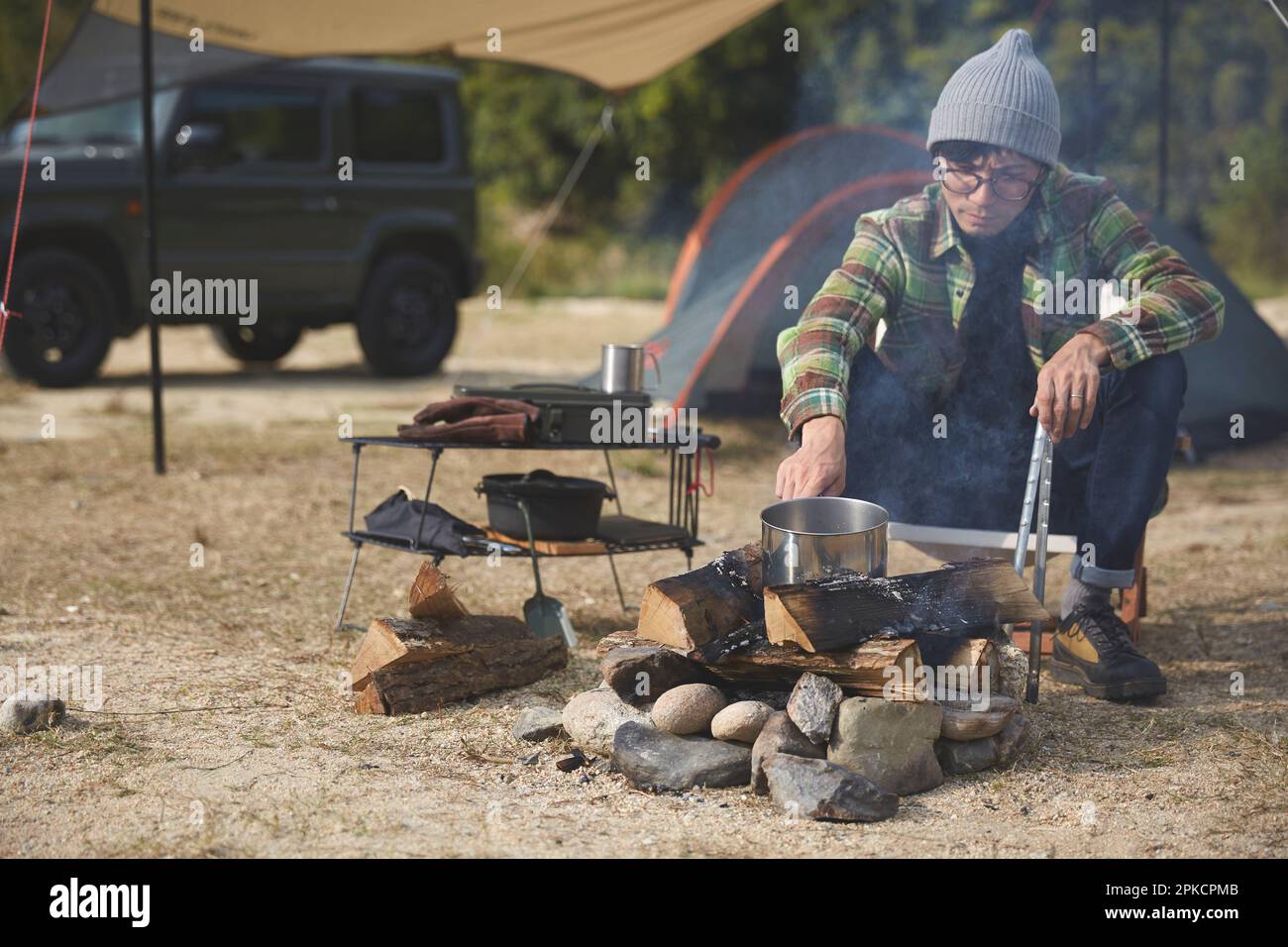 Man boiling water over an open fire Stock Photo Alamy
