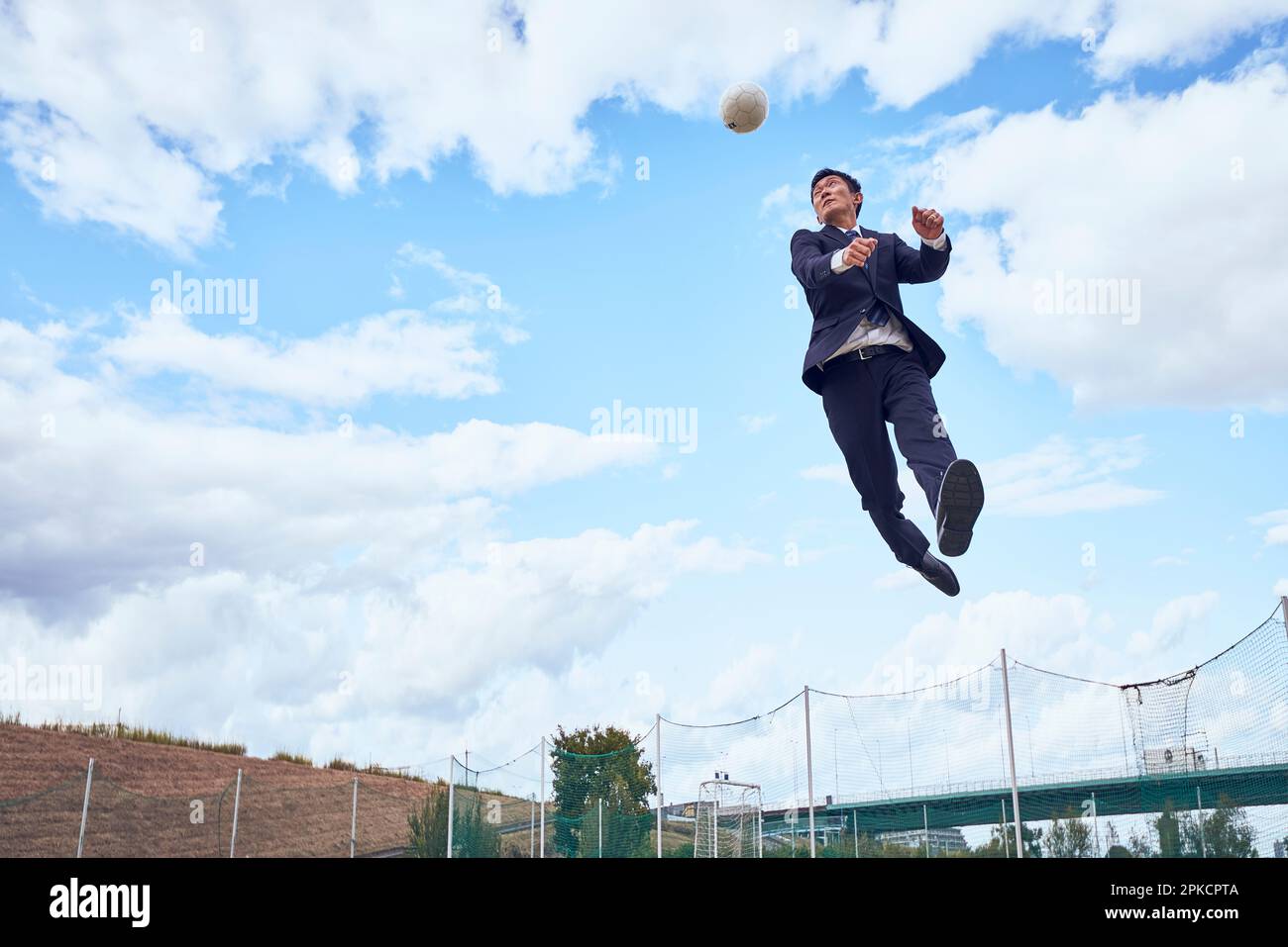 A businessman heading a soccer ball Stock Photo - Alamy