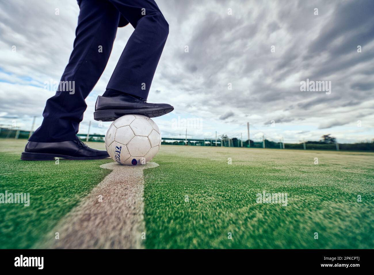 A businessman holding a soccer ball with his foot Stock Photo - Alamy