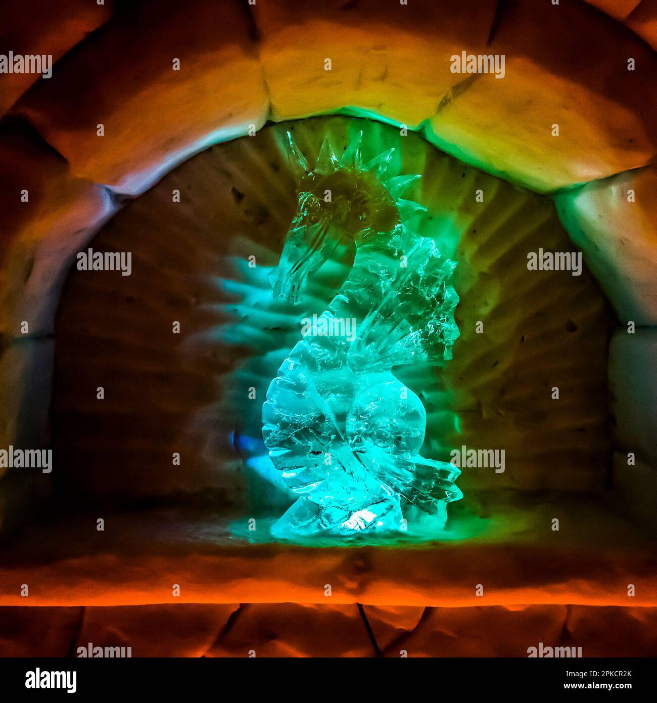 Inside the ice castle with colorful LED lights. Ice figurine of a