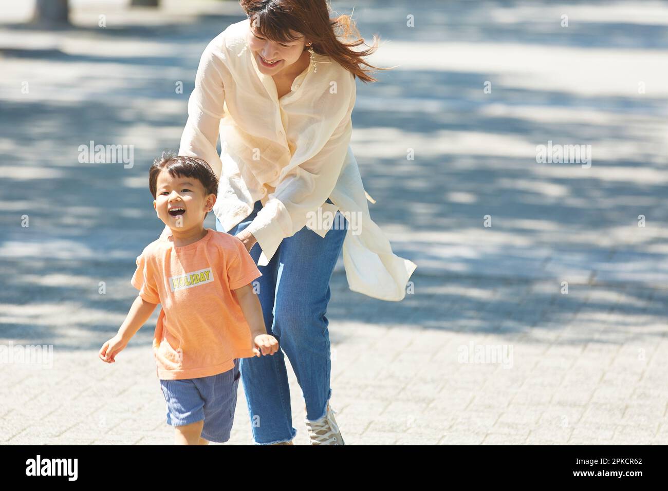 Mother chasing after her smiling son Stock Photo
