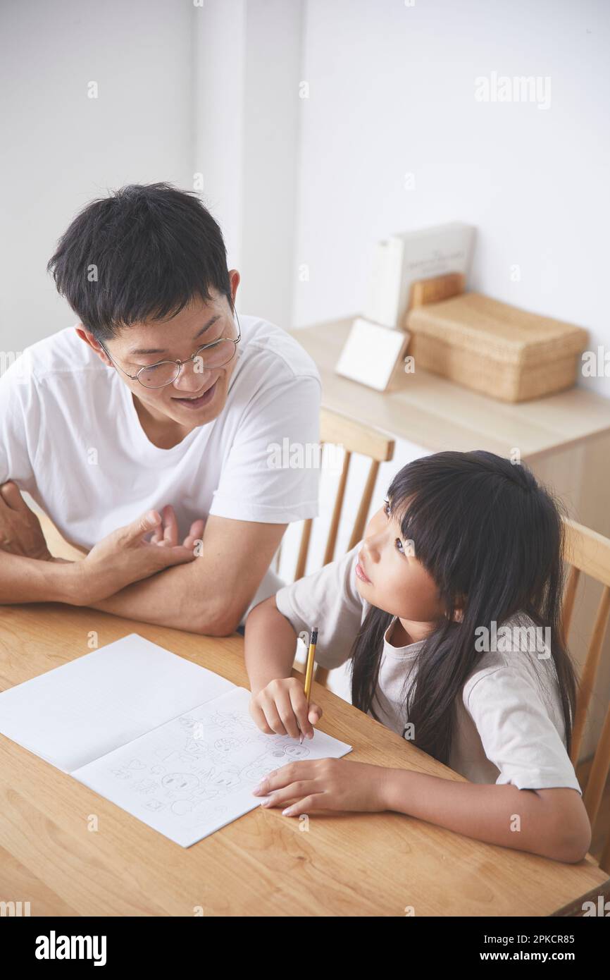 Girl getting help with homework from father stock photo alamy